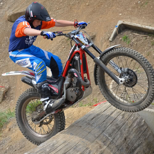 Un motocycliste effectue un saut sur une moto tout-terrain sur un parcours en terre.